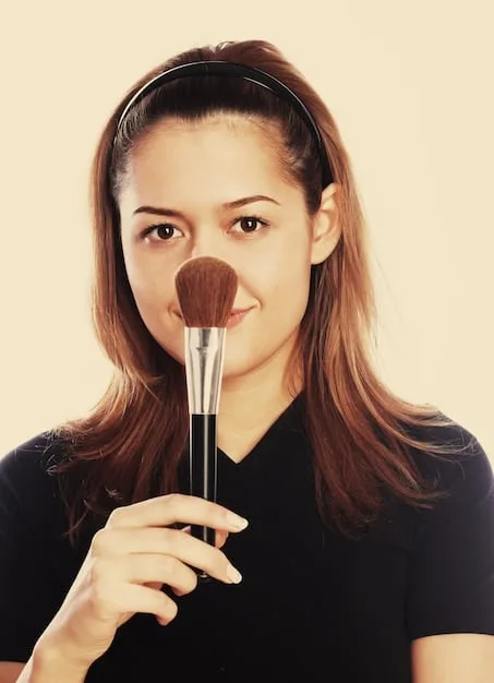 A makeup artist applying blush on a model's cheek with a fluffy brush, demonstrating a proper blush application technique.