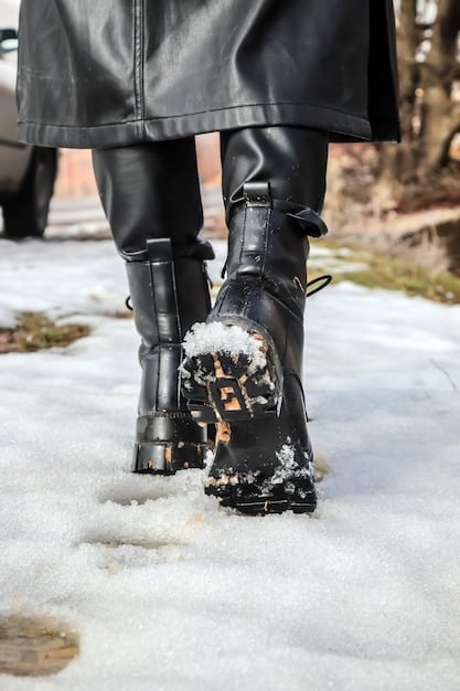 A pair of leather boots with visible white salt stains, highlighting the need for waterproofing. The background is a blurred image of a salted winter sidewalk.