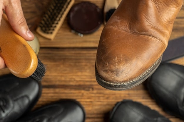 A person carefully cleaning a pair of leather shoes with a soft cloth and leather cleaner. The shoes are placed on a workbench, surrounded by shoe care products.
