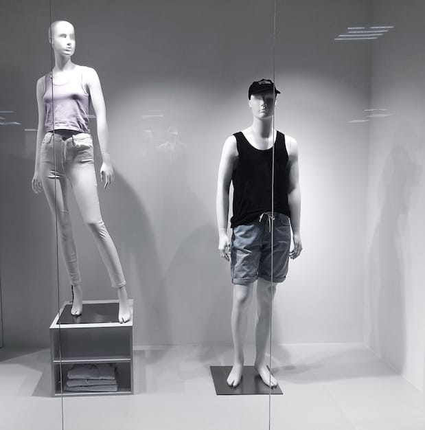 A sleek, minimalist Nike store display showcasing the sustainable clothing line. The display features mannequins wearing outfits made from the recycled and organic materials, with descriptive signage highlighting the ecological benefits and design elements. The store environment reflects a modern, clean aesthetic, aligning with the sustainable ethos of the collection and appealing to conscious German customers.