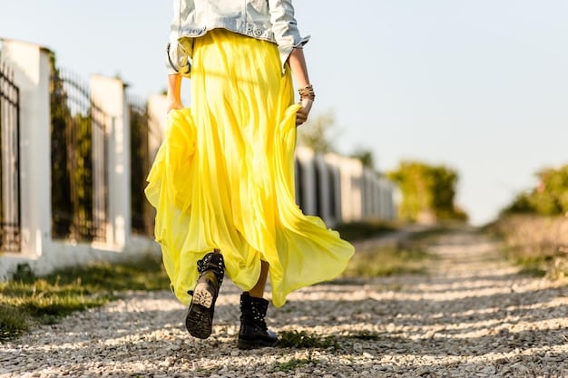 A model wearing a SHEIN 2025 Spring Collection outfit: a bright yellow, flowy skirt paired with a white, cropped top, walking down a cobblestone street in Germany, with traditional architecture in the background.