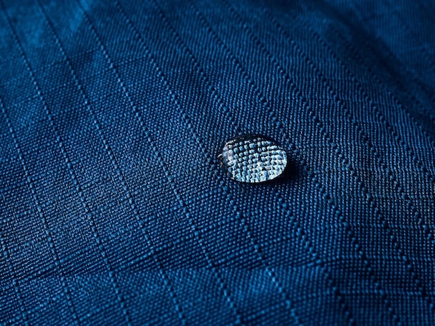 A close-up of Nike's Dri-FIT technology in action on a polo shirt. Sweat droplets are visibly being wicked away from the fabric, highlighting the moisture-management capabilities. The fabric texture is visible, showing the breathable and lightweight construction.