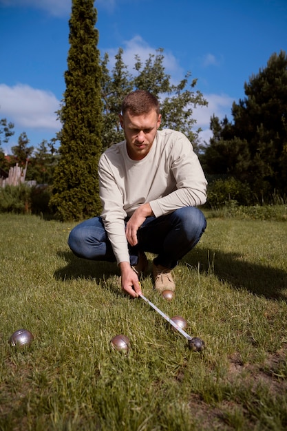 A German golfer is shown putting on a green, wearing Nike's new waterproof golf jacket from the 2025 collection. Raindrops are visible on the jacket's surface, demonstrating its water-repellent capabilities. The golfer appears focused and comfortable despite the wet weather conditions.