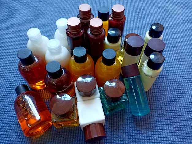 A close-up shot of various perfume bottles with atomizers, each labeled to indicate its fragrance family (floral, oriental, woody, fresh). The focus is on the fine mist being sprayed, showcasing the delicate application of fragrance layering.