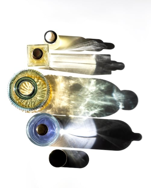 A split image showing two perfume bottles. On the left, the bottle is slightly faded and sits in a brightly lit, overly warm environment. On the right, the bottle is vibrant and sits in a cool, shaded environment. This illustrates the effect of temperature on perfume quality.