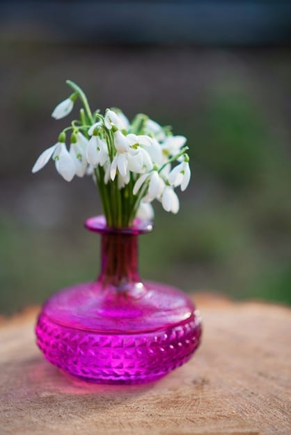 A close-up shot of a bouquet of various flowers, such as roses, jasmine, and lilies, with a blurred background of a perfume bottle, emphasizing the floral notes in fragrances.