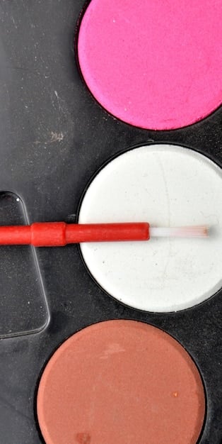 A close-up shot of a textured silicone makeup brush cleaning mat with various grooves and patterns. A makeup brush is being swirled across the mat, with soapy water visible around the bristles, highlighting the cleaning process.